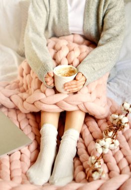 Pembe dev Merinos yün ekose battaniye fincan Cappuccino ile yatağa oturan genç kadın Foto Sabah konsepti Vintage tonda