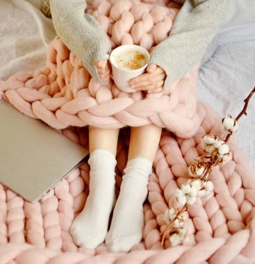 Pembe dev Merinos yün ekose battaniye fincan Cappuccino ile yatağa oturan genç kadın Foto Sabah konsepti Vintage tonda