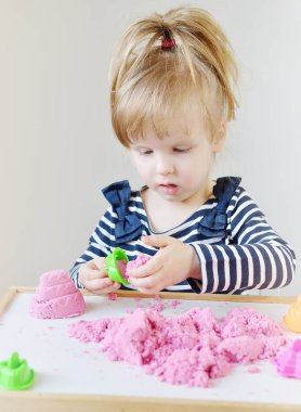 Erken eğitim okulu, geliştirme için hazırlanıyor, pembe Kinetik kum ile evde oynarken küçük beyaz kız