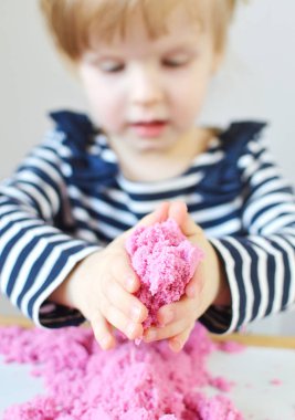 Erken eğitim okulu, geliştirme için hazırlanıyor, pembe Kinetik kum ile evde oynarken küçük beyaz kız