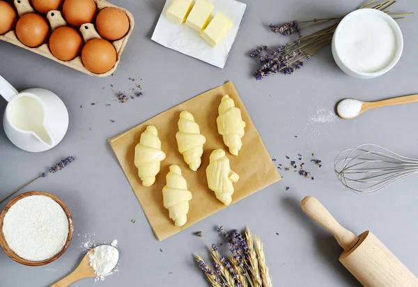 Baking Ingredients for Cooking Croissants. Dough, Eggs, White Sugar, Flour, Milk, Oil Butter. Preparation, Lavender Flowers. Kitchen Cuisine Table Grey Background, Homemade