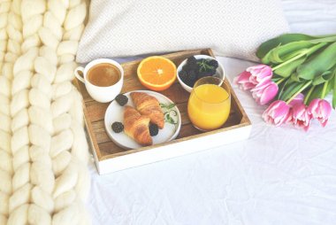 Odaya yatak, kruvasan, kahve fincanı, çilek, portakal suyu, Pembe Lale, çiçek romantik tarzı, dev beyaz Merinos yün battaniye, ahşap tepsi, tonda fotoğraf