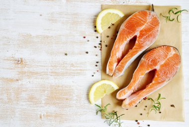 Somon alabalık balık ham fileto yemek biber tuz zeytinyağı biberiye limon yeşil domates salatası ahşap masa yaşam tarzı sağlıklı kavramı