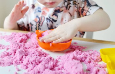Pembe Kinetik kum ile evde, erken eğitim oynarken küçük beyaz kız Lisesi, geliştirme, hazırlama plastik kalıpları