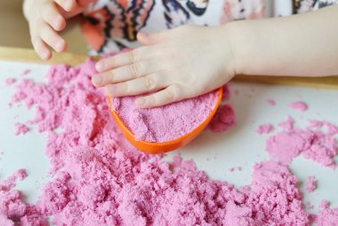 Pembe Kinetik kum ile evde, erken eğitim oynarken küçük beyaz kız Lisesi, geliştirme, hazırlama plastik kalıpları