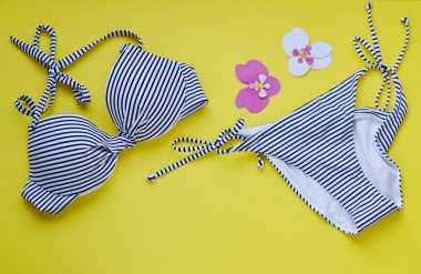 Kadın bikini mayo ve hasır şapka, yaz saati en iyi görünüm düz sarı arka plan kopya alanı afiş kavramı, tropikal yaprak çiçek koymak