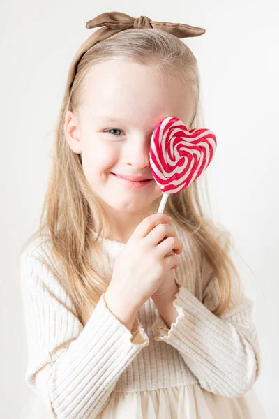 小さな女の子の肖像画とハートキャンディーの棒 ロリポップ テキストのためのコピースペース バレンタインデー 白い背景 — ストック写真