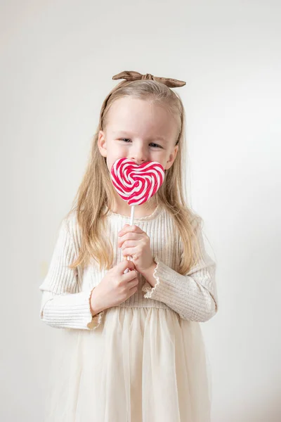 小さな女の子の肖像画とハートキャンディーの棒 ロリポップ テキストのためのコピースペース バレンタインデー 白い背景 — ストック写真