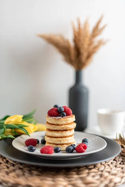 Cottage cheese pancakes with berries, healthy breakfast, yellows tulips, spring, woman\'s day