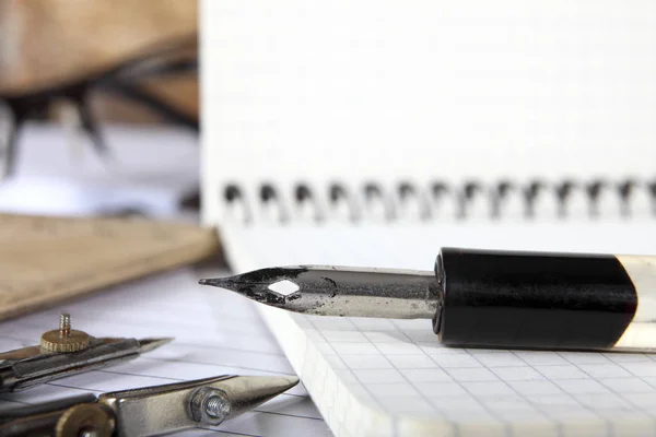 Pemisah dan penholder lama dengan pena terletak pada notebook dijahit dengan pegas logam di atas meja kayu. Fokus selektif. Foto bergaya retro. Close-up . — Stok Foto