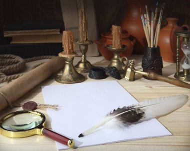 Ahşap masanın üstünde: Bir mühür ile kaydırma, yaprak beyaz kağıt, kaz tüyü, bir InkWell, Büyüteç, bronz retro şamdan mumlar, eski kitaplar ve seramik testi. Retro stilize fotoğraf