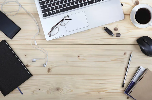 On the desktop in the office. Coffee-break with a phone, a laptop, a memory card and working notebooks. View from above. Close-up. — Stock Photo, Image