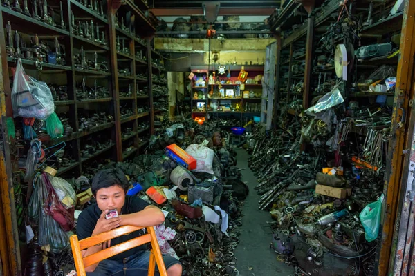 BANGKOK, THAÏLANDE / 03 AVRIL 2015 : Jeune homme vente de pièces détachées de voitures démontées — Photo