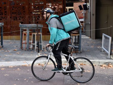 Perth, Avustralya - 30 Mayıs 2017: Şehir Merkezi sokakta Bisiklete binme A Deliveroo binici.
