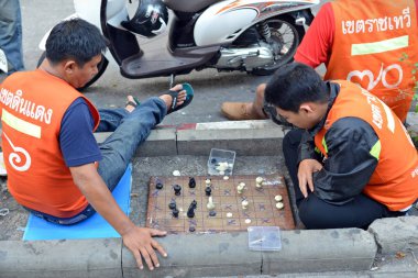 Bangkok, Tayland - 20 Mart 2014: Motosiklet taksi binici Makruk veya Tay satranç şehir merkezi sokak üzerinde oynamak