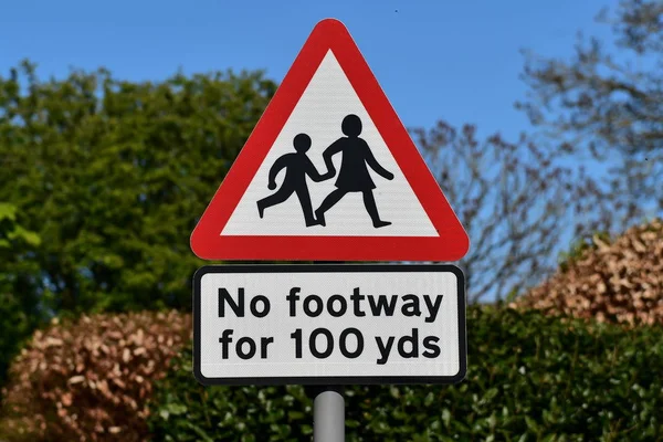 warning road sign with inscription no footway for 100 yds