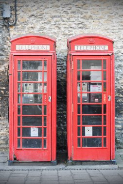 Eski tuğla duvar arka plan üzerinde kırmızı telefon kutuları closeup