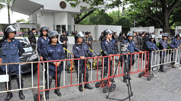 BANGKOK - June 16, 2013: Police stand guard at Royal Thai Police HQ as anti government activists rally.