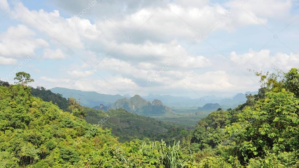 Mountain peaks with rich vegetation, clouds and blue sky