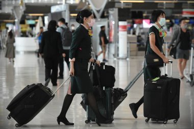 Bangkok, Tayland - 18 Şubat 2020: Maskeli gezginler Suvarnabhumi Havaalanı 'nın kalkış salonundan geçiyor. Tayland, Çin dışında Covid-19 virüsü riski altında..