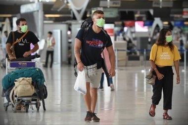 Bangkok, Tayland - 18 Şubat 2020: Maskeli gezginler Suvarnabhumi Havaalanı 'nın kalkış salonundan geçiyor. Tayland, Çin dışında Covid-19 virüsü riski altında..