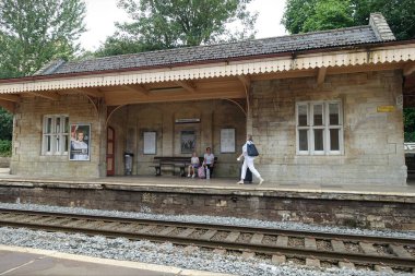 Bradford Avon, İngiltere - 4 Temmuz 2018: Demiryolu yolcuları bir tren istasyonunda bekliyorlar.