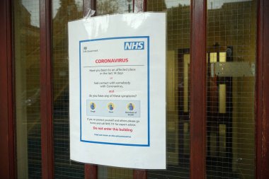 Bradford Avon, İngiltere - 5 Mart 2020: Coronavirüs ve covid-19 belirtilerini hastalara bildiren bir tıp kliniği dışında bir tabela görüldü.