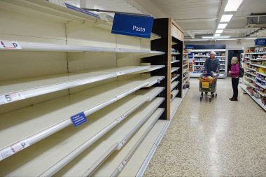 Londra, İngiltere - 16 Mart 2020: Tesco süpermarketinde boş raflar görülüyor. Dünya çapındaki perakende satış mağazaları, covid-19 kaynaklı stoklama nedeniyle bazı ev ihtiyaçlarının düşük olduğunu rapor etti..