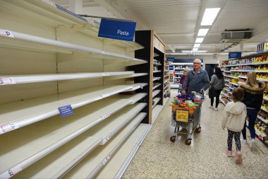 Londra, İngiltere - 16 Mart 2020: Tesco süpermarketinde boş raflar görülüyor. Dünya çapındaki perakende satış mağazaları, covid-19 kaynaklı stoklama nedeniyle bazı ev ihtiyaçlarının düşük olduğunu rapor etti..