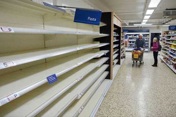 Londra, İngiltere - 16 Mart 2020: Tesco süpermarketinde boş raflar görülüyor. Dünya çapındaki perakende satış mağazaları, covid-19 kaynaklı stoklama nedeniyle bazı ev ihtiyaçlarının düşük olduğunu rapor etti..