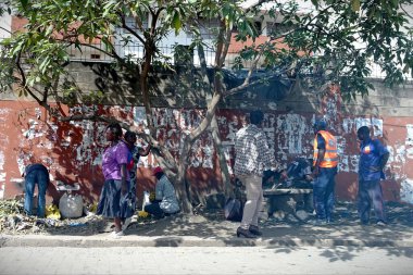 Nairobi, Kenya - 14 Şubat 2018: İnsanlar şehir merkezindeki bir caddede gölgeli bir ağacın altında toplandı.