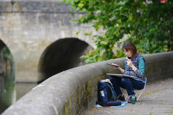 girl sitting on the bench and reading a book
