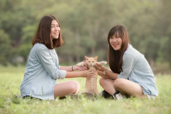 Hermosas mujeres jugando con gato — Foto de Stock