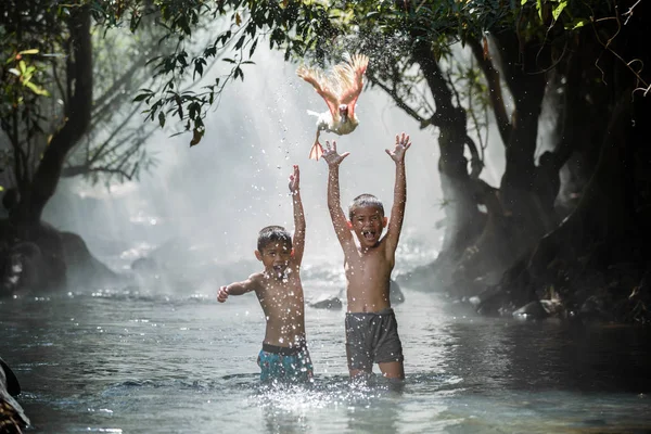 Мальчики играют в ручье — стоковое фото
