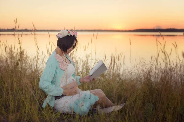 Gravid kvinna läser Stockfoto