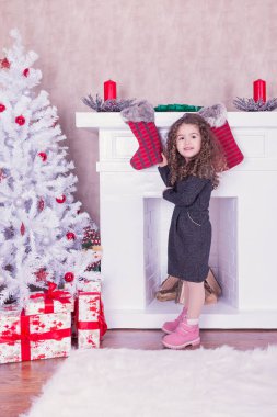 Noel bir şömine yakınındaki oldukça tatlı küçük kız portresi