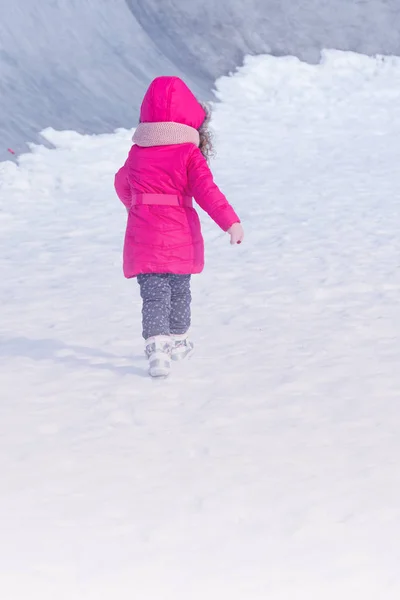 Pequena menina doce bonito ao ar livre jogando no parque de neve de inverno — Fotografia de Stock