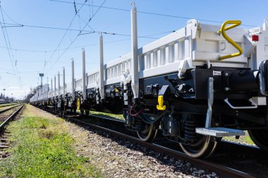 Burgas, Bulgaria - March 20, 2017 - Freight cargo train - 4axled flat wagon white Type:Rens Model:192, B - Transvagon AD clipart