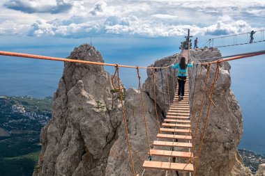 Kız asma köprü üzerinde uçurumun gider.