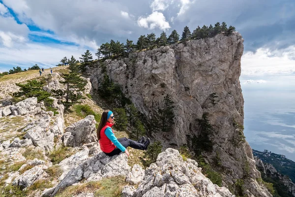 Dívka sedí na okraji útesu — Stock fotografie