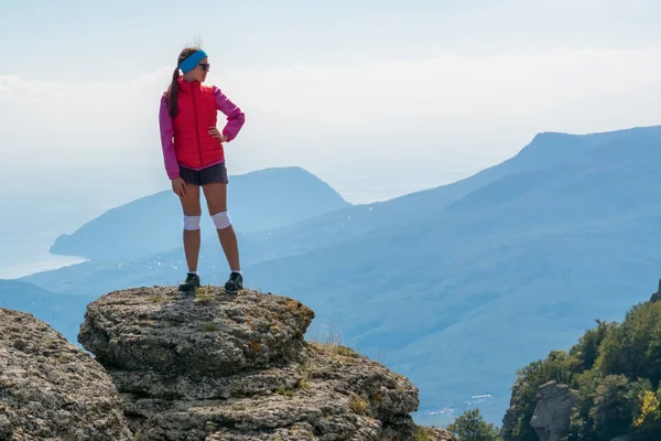 Turistické dívka stojící na velké skále — Stock fotografie