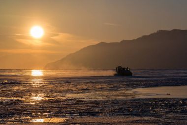 Hovercraft rides on Lake Baikal ice clipart