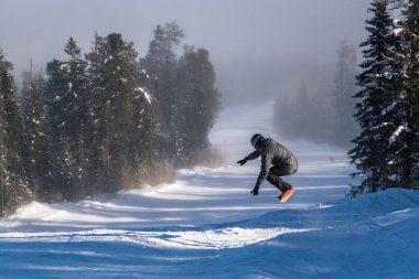 Snowboard atlar karlı tepeden aşağı