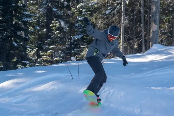 Snowboardista sklouzne ze zasněženého kopce — Stock fotografie