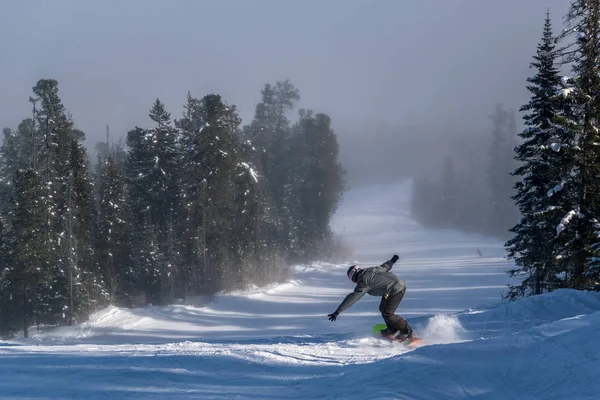 Snowboardåkare glider nerför den snöiga backen — Stockfoto