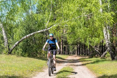 Bir kız bir orman yolu üzerinde bir bisiklet sürme