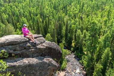 Kız bir uçurumun üstünde oturuyor