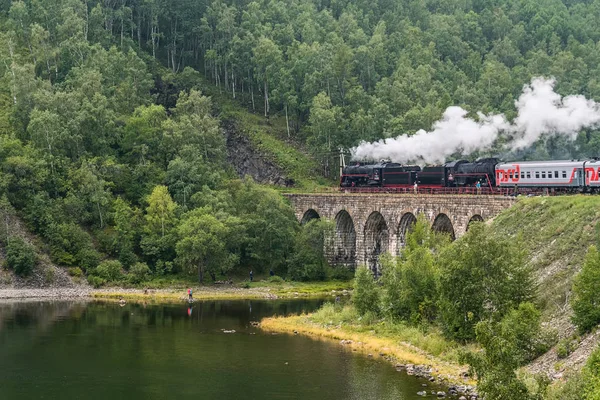 17 de agosto de 2017: A velha locomotiva a vapor está dirigindo ao longo da ponte na Circum-Baikal Railway, lago Baikal, Rússia — Fotografia de Stock