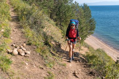 Bir turist tehlikeli bir yol boyunca bir uçurumun üzerinden yürür.