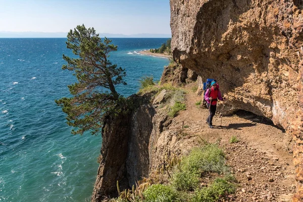 Seorang turis berjalan di sepanjang jalan berbahaya di atas tebing — Stok Foto